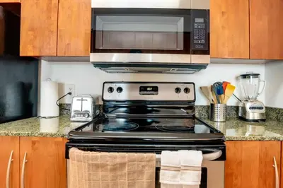 a kitchen with a stove and a microwave at One of Brickell Bays Best with Pool and Gym Access in Miami