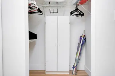 a closet with white cabinets and an umbrella at One of Brickell Bays Best with Pool and Gym Access in Miami