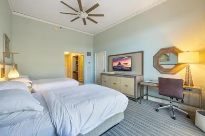 a bedroom with two beds and a desk and a television at Charming 5 Star Condo Unit Situated at Ritz Carlton-Key Biscayne in Miami