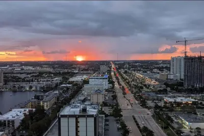 a view of a city with the sunset in the background at Contemporary Beach Retreat, Sleek Design & Full Kitchen -A in Hallandale Beach