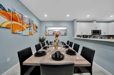 a dining room with a wooden table and chairs at Luxury Duplex in Heart of Fort Lauderdale Near The Beach in Fort Lauderdale