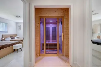 a bedroom with a door leading to a bathroom at Luxury 7BR Villa Vizcaya Pool Sauna Gym Golf in Miami
