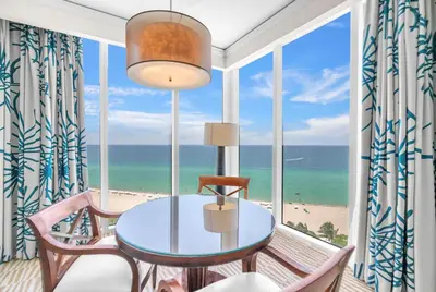 a dining room with a view of the beach at TRUMP INTERNATIONAL BEACH RESORT 2 BEDROOM APARTMENT 1600 Sqf OCEAN FRONT in Miami Beach