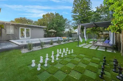 a backyard with a game of chess on the lawn at La Playita 4-BR Heated Pool Miami 16 Guests in Miami