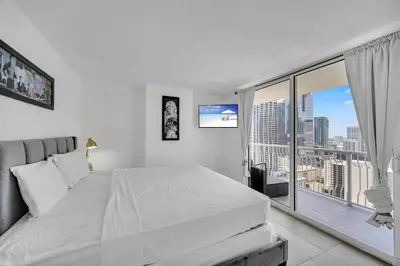 a bedroom with a large white bed and a large window at 37th floor Amazing spacious unit with parking in Miami