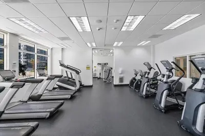 a gym with rows of treadmills and elliptical machines at Ocean front private unit in Miami