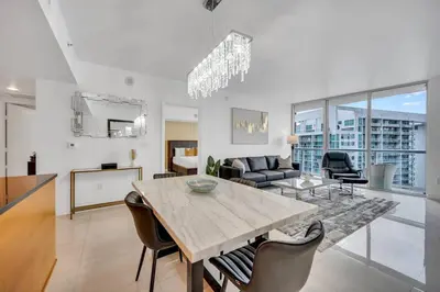 a dining room and living room with a table and chairs at 38th floor W residence with amenities in Miami
