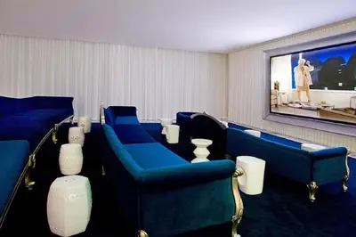 a waiting room with blue chairs and a large screen at 38th floor W residence with amenities in Miami