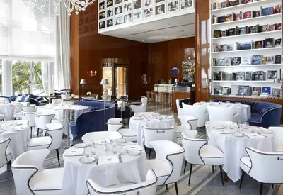 a dining room with white tables and white chairs at 38th floor W residence with amenities in Miami