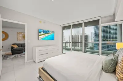 a white bedroom with a large bed and a tv at Luxurious Ocean View Unit Brickell W residences in Miami