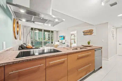 a kitchen with wooden cabinets and a sink at Luxurious Ocean View Unit Brickell W residences in Miami