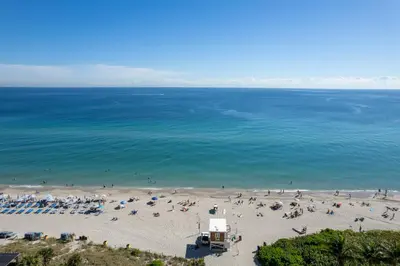 an aerial view of a beach with people on it at Water View Building With Pool - 5-Min Walk To The Beach in Hallandale Beach