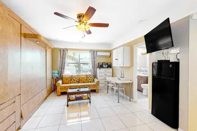 a kitchen with a ceiling fan and a living room at Eternal Coastal Sunshine in Hollywood