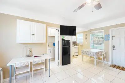 a kitchen with a table and a black refrigerator at Eternal Coastal Sunshine in Hollywood