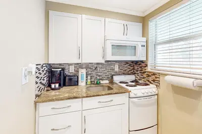 a kitchen with white cabinets and a sink and a microwave at Eternal Coastal Sunshine in Hollywood