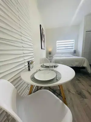 a white room with two beds and a table and chairs at Alma Guest Suite in Miami