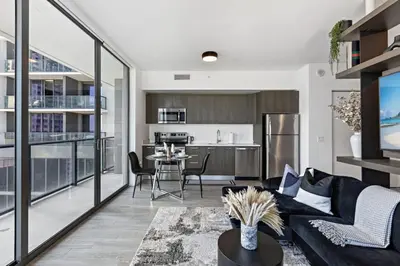 a living room with a couch and a kitchen at Corner condo w/ Unrivaled views in Miami