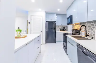 a kitchen with white cabinets and a black refrigerator at Angies-10 Min Beach-10 People-Terrace-Families in Hollywood