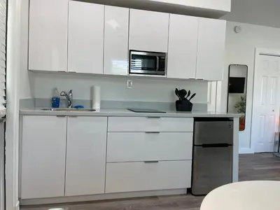 a kitchen with white cabinets and a microwave at Casa Habana Studios in Miami
