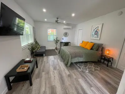 a bedroom with a bed and a flat screen tv at Casa Habana Studios in Miami