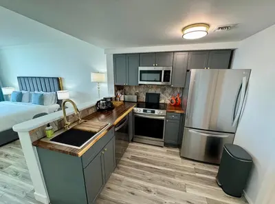 a kitchen with a stainless steel refrigerator next to a bed at Balcony Ocean View ! WiFi - Pool - Gym - Parking in Miami