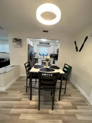 a dining room with a table and chairs and a kitchen at Modern Tropical Oasis with Arcade, HotTub & MiniGolf in Hollywood