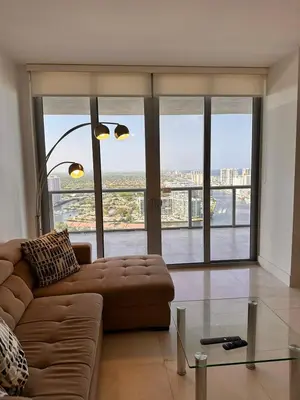 a living room with a couch and a large window at Oceanview Luxury 2BR with Pool & Beach in Hallandale Beach