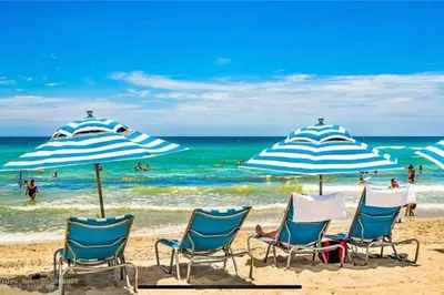 a group of chairs and umbrellas on a beach at Oceanview Luxury 2BR with Pool & Beach in Hallandale Beach