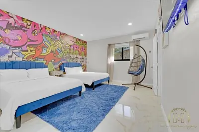 a bedroom with two beds and a mural on the wall at Game & Chill Manor - Arcade - Pool - Pool table in Fort Lauderdale