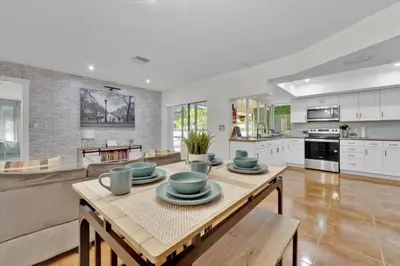 a kitchen and living room with a table with bowls on it at Game & Chill Manor - Arcade - Pool - Pool table in Fort Lauderdale