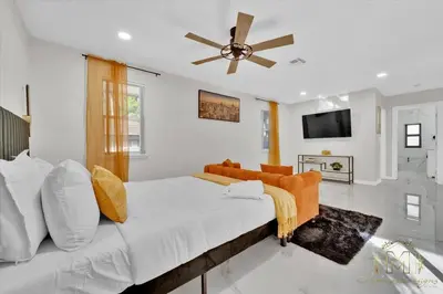 a bedroom with a large bed and a ceiling fan at Game & Chill Manor - Arcade - Pool - Pool table in Fort Lauderdale