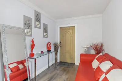 a living room with a red couch and a yellow door at Patio and Yard Family-Friendly Miami Oasis! in Miami Gardens