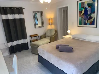 a bedroom with a large bed and a chair at Manhattan Tower Apartment Hotel in Fort Lauderdale