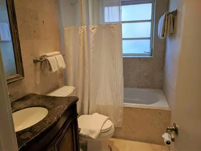 a bathroom with a sink and a toilet and a tub at Manhattan Tower Apartment Hotel in Fort Lauderdale