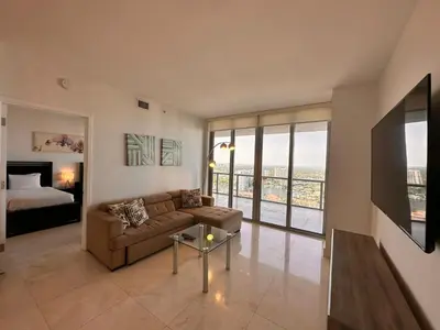a living room with a couch and a bed at Oceanview 2BR with Beach & Pool -Hallandale in Hallandale Beach