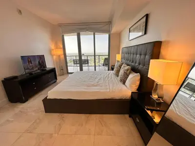 a bedroom with a large bed and a large window at Oceanview 2BR with Beach & Pool -Hallandale in Hallandale Beach