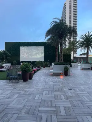 a large patio with palm trees and a screen at Luxury 2 bedroom with ocean view in Hollywood