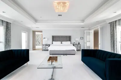 a bedroom with a bed and two couches at Incredible 9 Bedroom 11 Bath Idlewyld Mansion in Fort Lauderdale
