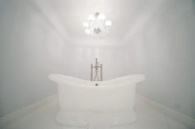 a white bath tub in a room with a chandelier at Incredible 9 Bedroom 11 Bath Idlewyld Mansion in Fort Lauderdale