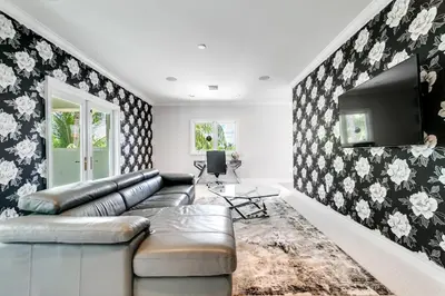 a living room with a couch and a tv at Incredible 9 Bedroom 11 Bath Idlewyld Mansion in Fort Lauderdale