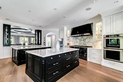 a large kitchen with black and white appliances at Incredible 9 Bedroom 11 Bath Idlewyld Mansion in Fort Lauderdale