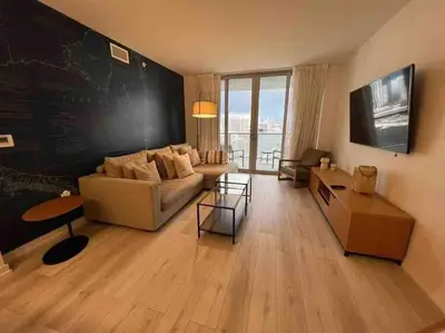 a living room with a couch and a chalkboard wall at Sophisticated Beach Escape, Breathtaking Views & Comfort -2A in Hallandale Beach