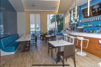 a restaurant with tables and chairs and a bar at Sophisticated Beach Escape, Breathtaking Views & Comfort -2A in Hallandale Beach