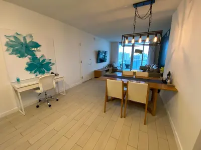 a living room with a table and chairs and a desk at Cozy Beach Apartment, Full Kitchen & Ocean Views -A in Hallandale Beach