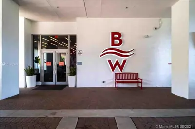 a red bench in front of a building with a bwk sign at Cozy Beach Apartment, Full Kitchen & Ocean Views -A in Hallandale Beach