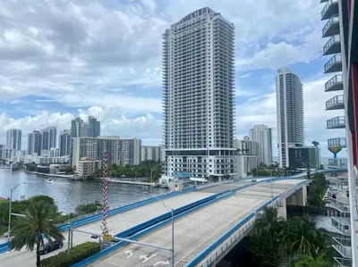 a bridge over a river in a city with tall buildings at Cozy Beach Apartment, Full Kitchen & Ocean Views -A in Hallandale Beach