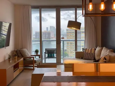 a living room with a couch and a large window at Seaside Retreat in Miami, Full Kitchen & Balcony Views -A in Hallandale Beach
