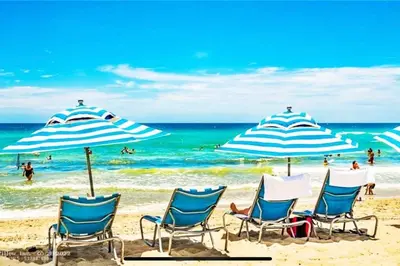 a group of chairs and umbrellas on a beach at Ocean Air & 2 Cozy Full Beds, Relaxing Beach Studio in Hallandale Beach