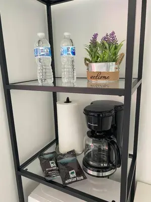 a shelf with a coffee maker and water bottles at Ocean Air & 2 Cozy Full Beds, Relaxing Beach Studio in Hallandale Beach
