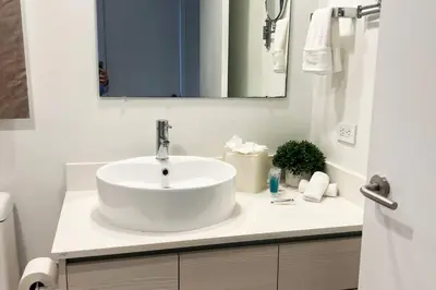 a white bathroom with a sink and a mirror at Chill Out in This Stylish 2-Full Bed BeachWalk Studio in Hallandale Beach
